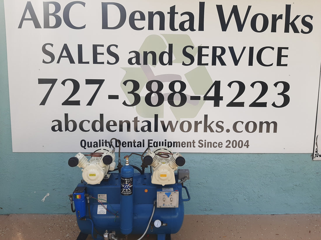 Tech West ACO4D2 oil-less dental air compressor, full front view of the blue tank and both motor heads on a pallet outdoors.