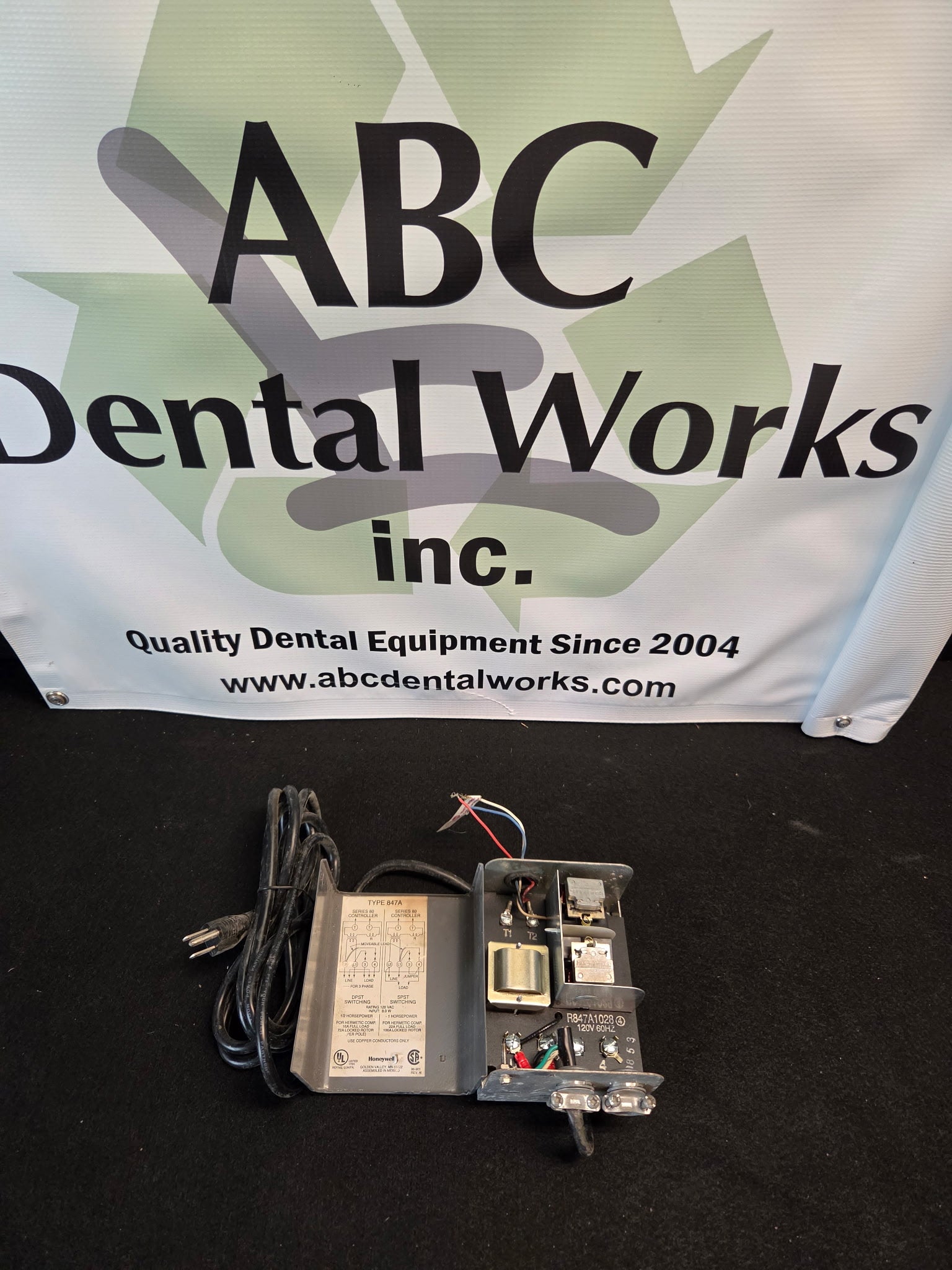 Honeywell R847A1028 switching relay with cover open showing the internal transformer, relay contacts, T1 and T2 low-voltage terminals and wiring diagram label