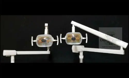 A-dec 6300 post mount operatory light: two complete light head and arm assemblies shown side by side against a black backdrop.