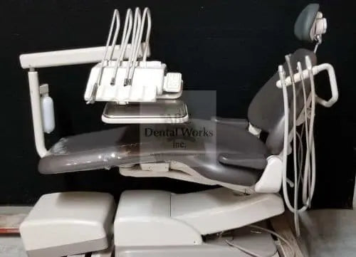 A-dec Cascade 1040 dental chair with gray upholstery, radius delivery unit holding four handpiece tubings, assistant's arm and headrest.