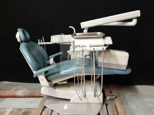 A-dec 1021 Decade Cascade package: teal upholstered chair with over-the-patient delivery unit, handpiece tubing, tray and overhead light arm, on a pallet