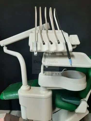 A-dec 2150 Cascade delivery unit front view, five handpiece tubings on the instrument holder above the cuspidor bowl; green chair behind is staging