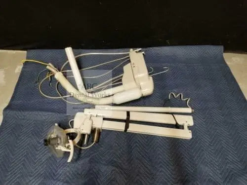 A-dec 6300 light and Performer cuspidor assembly shown disassembled on a blanket — arm segments, light head and mounting brackets