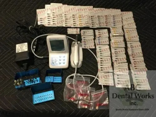 Brasseler NSK EndoDrive Plus kit laid out — control unit, micromotor handpiece, AC adapter, two bur blocks and rows of packaged endodontic files