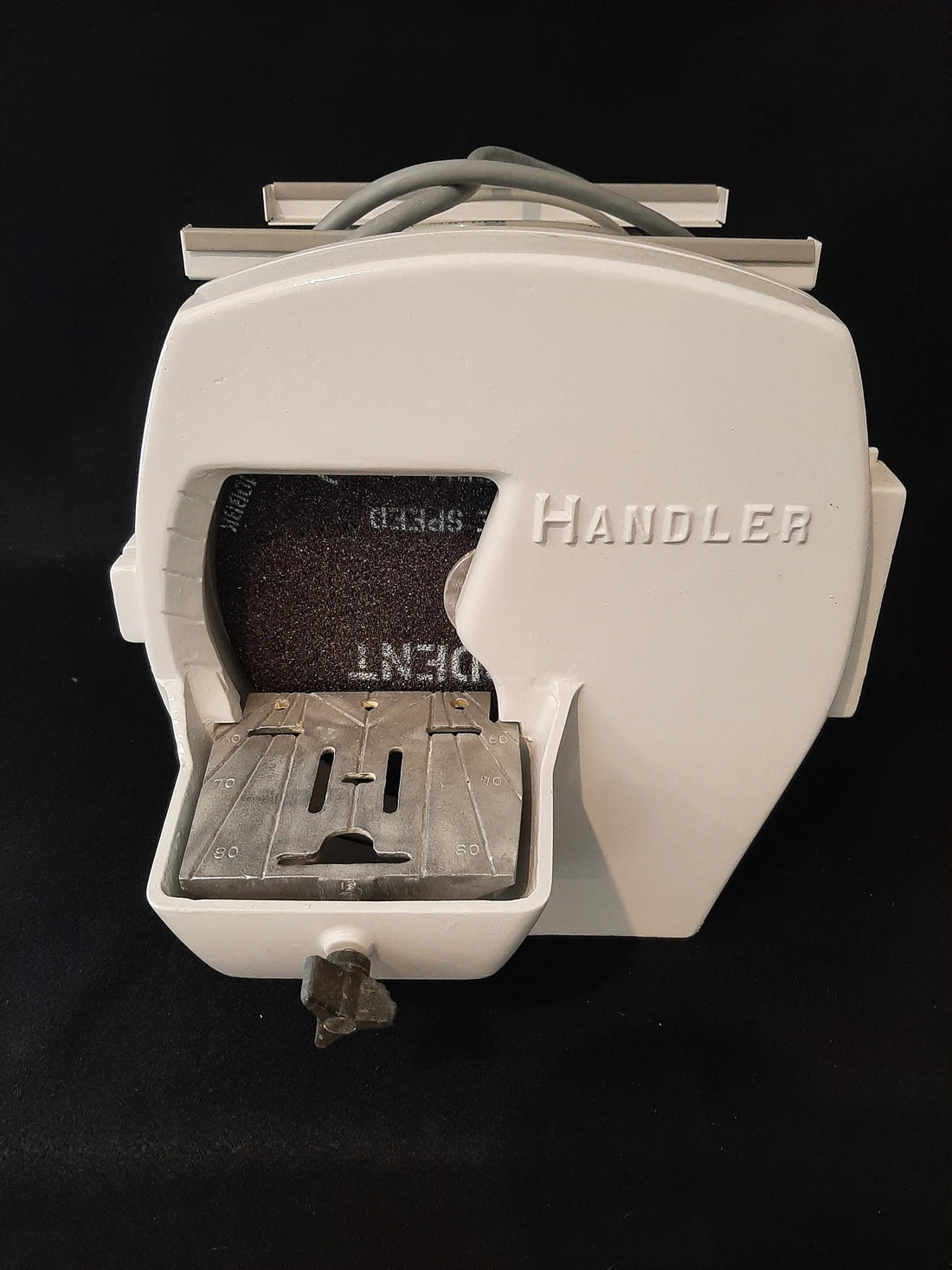 Handler Model 31 model trimmer, front view on a black backdrop showing the HANDLER housing, grinding wheel and stainless work table.