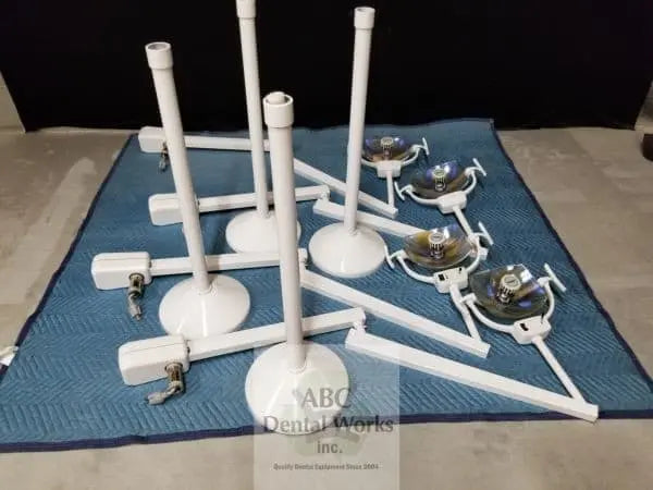 Four Marus LuxStar CL1000 ceiling-mount light assemblies laid out disassembled on a blanket — drop posts, round ceiling canopies, arms and light heads