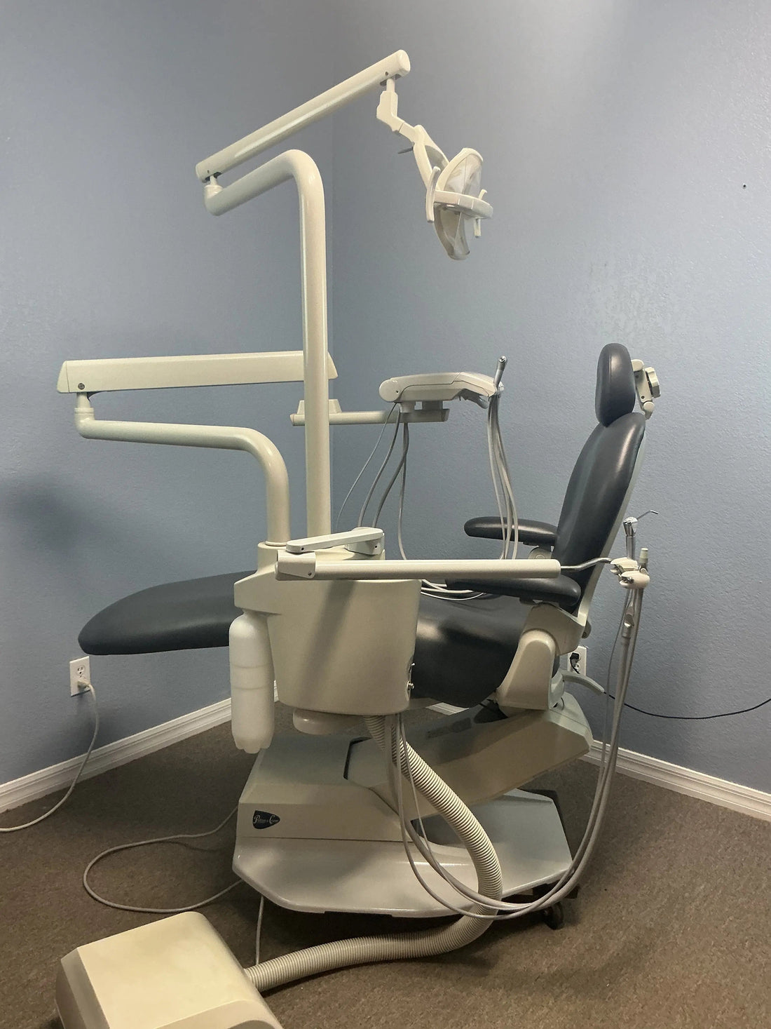 Pelton & Crane Spirit 2000 operatory set up in a showroom corner: charcoal chair, post-mounted delivery unit, LF II light and foot control.