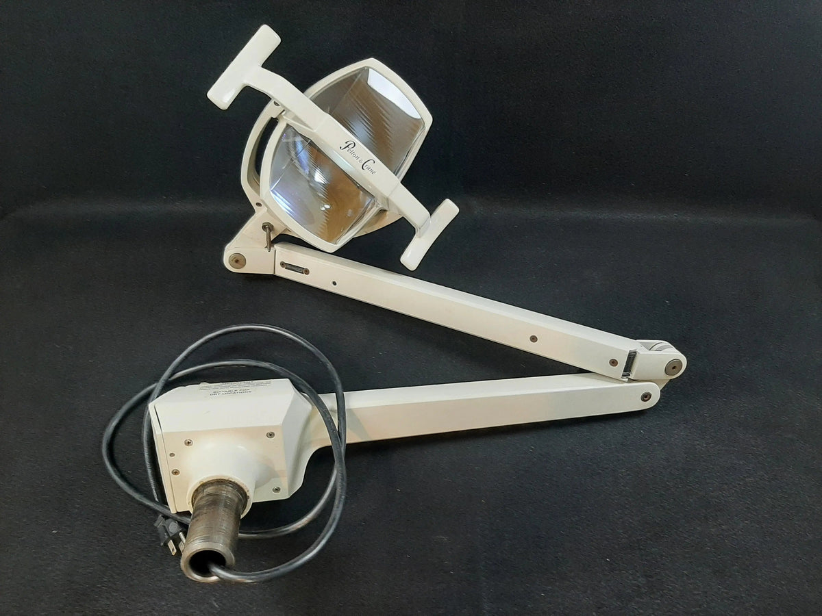 Pelton & Crane LF II operatory light fully detached and laid on a dark cloth: light head, two-section arm and post yoke with coiled power cable.