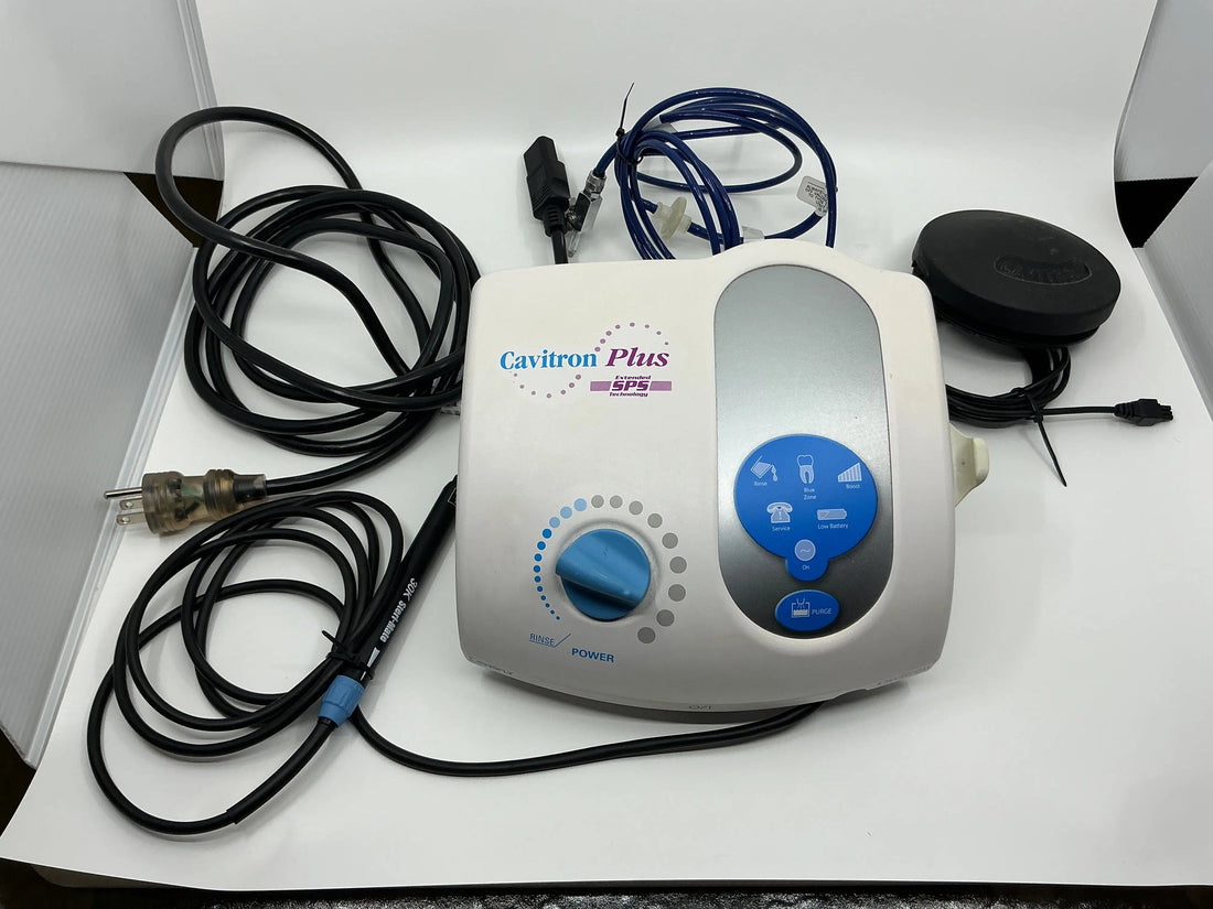 Dentsply Cavitron Plus SPS scaler seen from above with blue touchpad and Power dial, coiled cords, water line and round foot pedal.