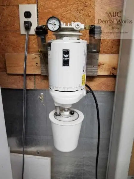 Wehmer Model 107 vacuum spatulator mounted on a plywood wall, white motor with vacuum gauge and mixing bowl fitted below