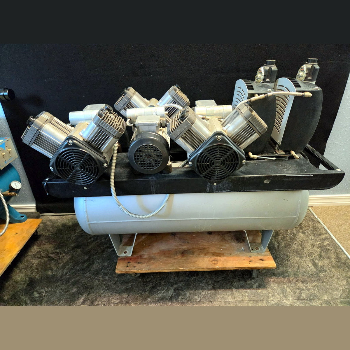 Air Techniques AirStar 70 AS70 dental air compressor, angled side view showing the 30-gallon air receiver tank, drain valve and rolling base, refurbished